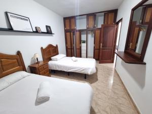马佐VV Mirador Isla Bonita "by henrypole home"的一间卧室配有两张床和镜子