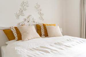 策勒Ferienwohnung Gartenkamp Celle的白色的床,配有黄色和灰色的枕头
