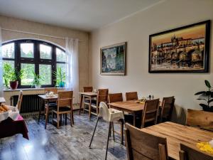 哈拉霍夫GRAND HARRACHOV PENSION v centru的餐厅设有木桌、椅子和窗户