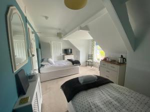 法尔茅斯柯莱特旅馆的一间卧室配有一张床和镜子