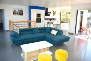 普雷兰Villa neuve sur pilotis vue mer à 30m de la plage的客厅配有蓝色的沙发和黄色的凳子