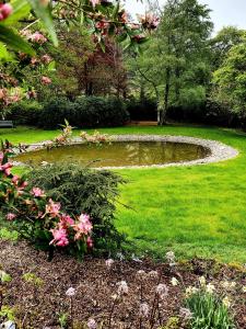凯西克The Leathes Head Hotel的草坪中间的池塘,有粉红色的花