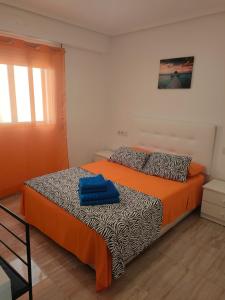 瓦伦西亚Altura的一间卧室配有一张带橙色和黑色棉被的床