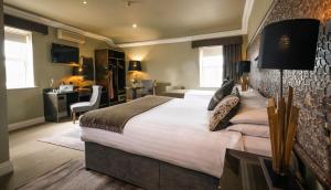 麦克鲁姆Castle Hotel Macroom的酒店客房设有一张大床和一张书桌。