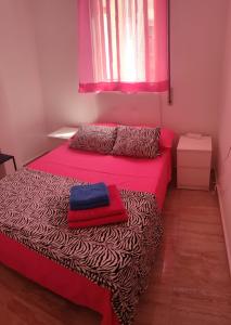 瓦伦西亚Altura的一间卧室设有两张床和粉红色的窗户。