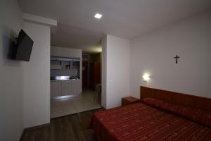 圣乔瓦尼·罗通多Hotel e Appartamenti La Solaria的一间带床的小卧室和一间厨房
