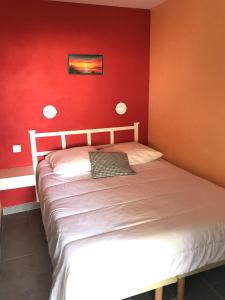 阿盖Cap Estérel by Actisource的一间卧室配有一张红色墙壁的床