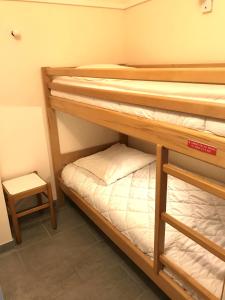 阿盖Cap Estérel by Actisource的小型客房设有两张双层床和凳子。