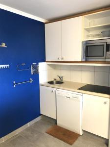 阿盖Cap Estérel by Actisource的厨房配有白色橱柜和蓝色的墙壁
