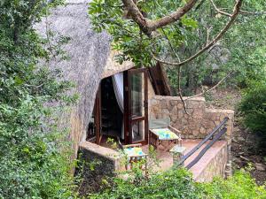 MatoposBig Cave Camp的树林里带门廊的树屋