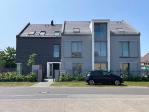 柏林附近贝尔瑙Wohnung im Gästehaus的停在房子前面的一辆黑色汽车