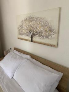 马莫亚达Su Hantaru Vetzu的上床墙上一棵树的画