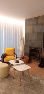 格兰杜拉Casa do Escorrega的客厅设有黄色椅子和壁炉