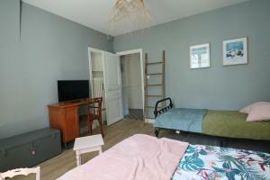 拉布尔布勒Le Gentiane - Villa Chanterive的一间卧室配有两张床、一张桌子和一台电视。