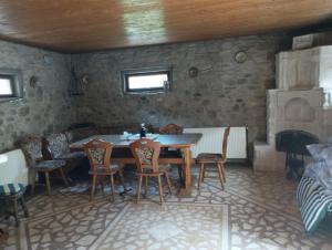 拉姆尼库沃尔恰Casa de pe lac Fedelesoiu ,的一间带桌椅和壁炉的用餐室