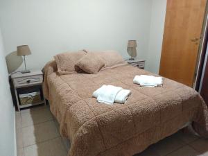 雅卡托镇Libertad的一间卧室配有一张床,上面有两条毛巾