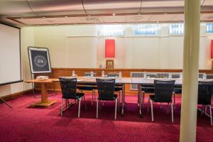 曼彻斯特曼彻斯特市政酒店的一间会议室,配有大桌子和椅子