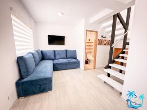 圣安德烈斯Casa Turística Praia House的客厅设有蓝色的沙发和楼梯。