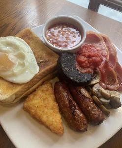 利物浦Fenwick Sunrise Hotel的包括鸡蛋香肠和烤面包的早餐食品