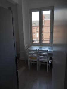 鲁昂Belle Chambre pour une personne的一间带桌椅和窗户的用餐室