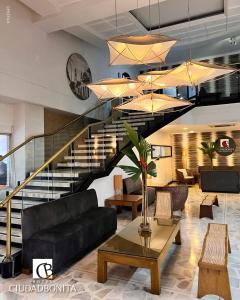 布卡拉曼加Hotel Ciudad Bonita的客厅设有黑色沙发和楼梯。