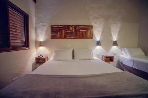 博尼图Bonito Ecotel的一间卧室配有一张带2个床头柜的大型白色床
