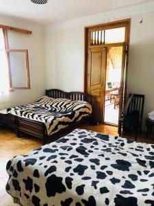 TsemiMTA的一间卧室配有两张带牛纹床单的床