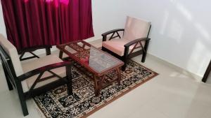 西姆拉Pal Homestay Shimla的客厅配有两把椅子和一张茶几