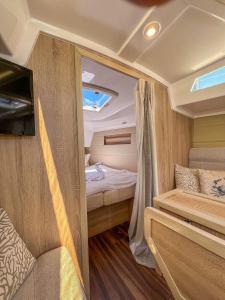 费曼城堡Hausboot Segelyacht Nui的小型大篷车设有一间卧室和一张床