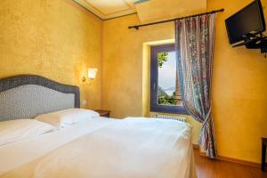 阿尔杰尼奥La Griglia HOTEL的卧室配有白色的床和窗户。