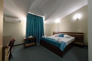 康斯坦察Hotel Cora的一间卧室配有床和蓝色窗帘