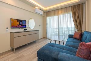 费特希耶IDEE SUİTES Fethiye的客厅配有蓝色的沙发和电视