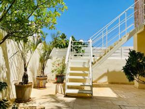 埃拉特Glamour Luxury Suite Swimming pool的建筑一侧有植物的白色楼梯