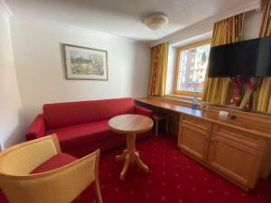 伊施格尔阿尔皮纳酒店的客厅配有红色的沙发和桌子