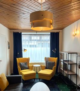 丁格尔Foxy View in Dingle Town!的客厅设有黄色椅子、桌子和窗户