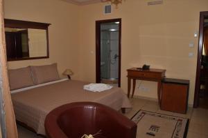 泰托沃蒂沃利酒店的一间卧室配有一张床、一张桌子和一面镜子