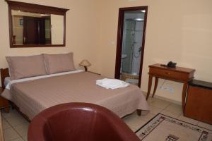 泰托沃蒂沃利酒店的一间卧室配有一张床、一张桌子和一面镜子