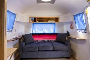 布拉格堡Cowabunga By Pacific Blue的客厅配有沙发,位于大篷车内