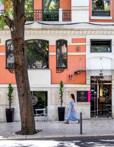 里斯本卢埃纳酒店的走在建筑物前的街道上的女人