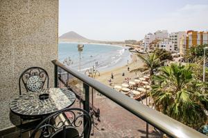 厄尔梅达诺Apartments Alba的一个带桌椅和海滩的阳台