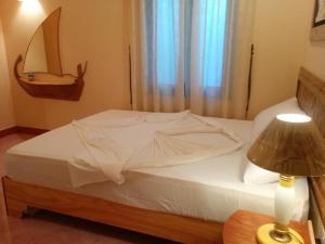 费利杜Vaali Maldives Island Escapes & Dive的卧室配有一张白色的床、桌子和台灯