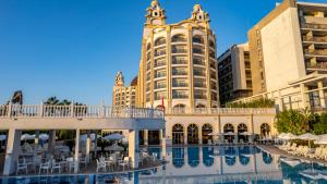 锡德J'adore Deluxe Hotel & Spa Ultra All Inclusive的大楼前设有游泳池的酒店