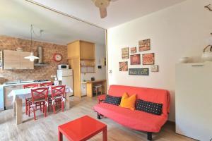 巴多利诺VOLTA游泳池和海滩公寓的一间带红色沙发的客厅和一间厨房
