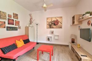 巴多利诺VOLTA游泳池和海滩公寓的客厅配有红色沙发和平面电视