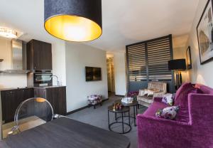 奥斯陆萨迦奥斯陆公寓的一间带紫色沙发的客厅和一间厨房