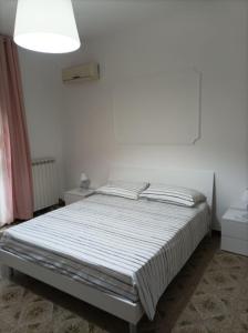 Leporano MarinaVilla Anna的白色卧室内的一张床位,卧室内拥有白色的墙壁