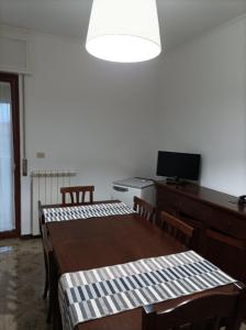 Leporano MarinaVilla Anna的一间设有两张桌子和一张书桌及电视的房间