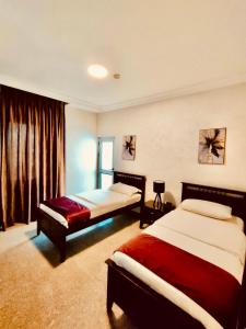 安曼Tamrah Suites Hotel的酒店客房设有两张床和窗户。