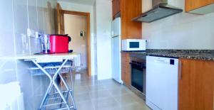 艾利亚德亚罗萨Apartamento playa Cabodeiro, en A Illa De Arousa的厨房配有白色冰箱和台面