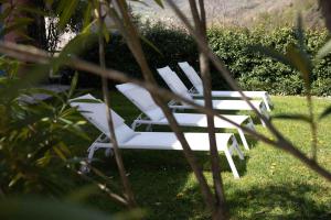 Vallio TermeBorgo alla Sorgente的一组坐在草地上的白色椅子